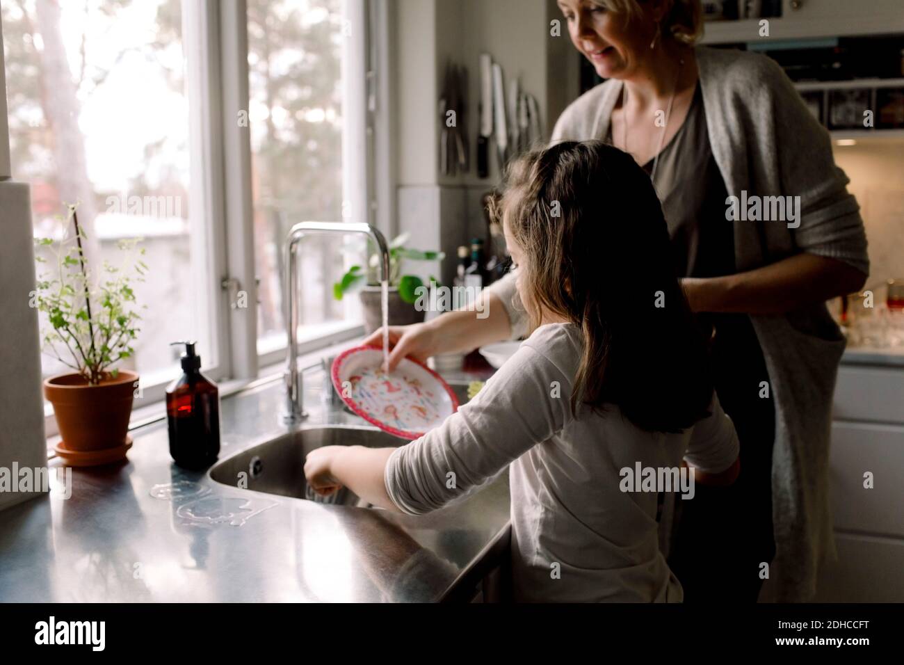 Fille aidant la mère dans la cuisine à la maison Banque D'Images
