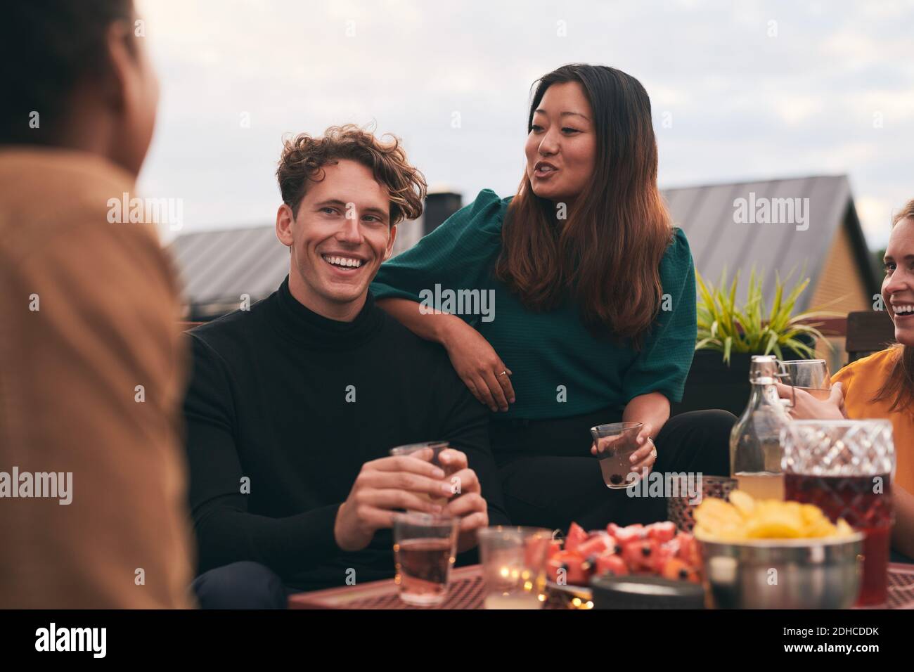 Personnes assises en train de boire un verre en terrasse en souriant et ...