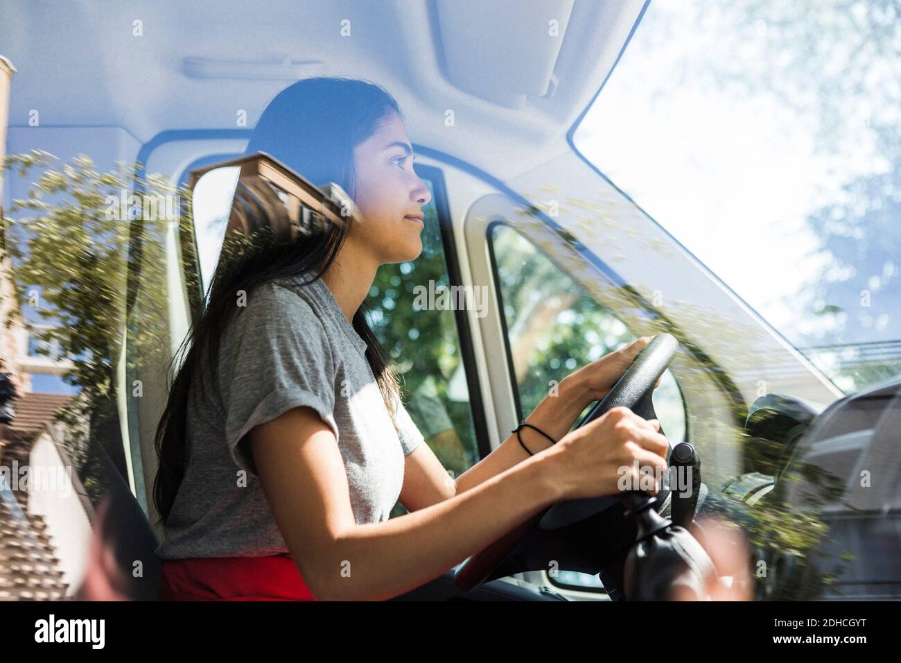 Vue latérale d'une jeune femme confiante conduisant un camion alimentaire Banque D'Images