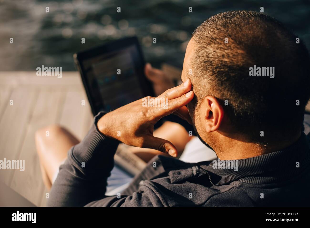 Vue en grand angle de l'homme avec une tablette numérique sur le patio Banque D'Images