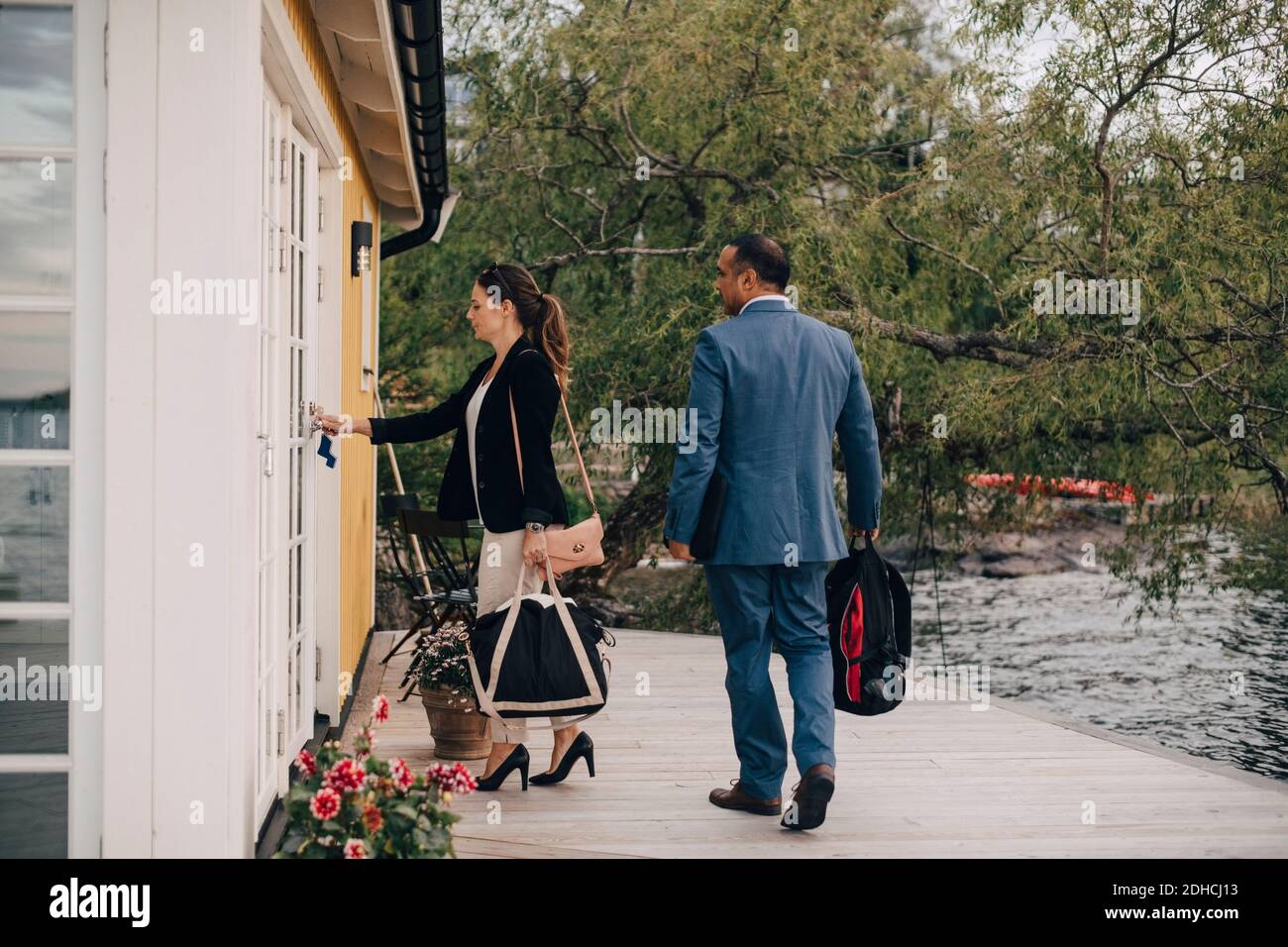 Pleine longueur de couple d'âge mûr ouvrant la porte à la villa de vacances par lac Banque D'Images