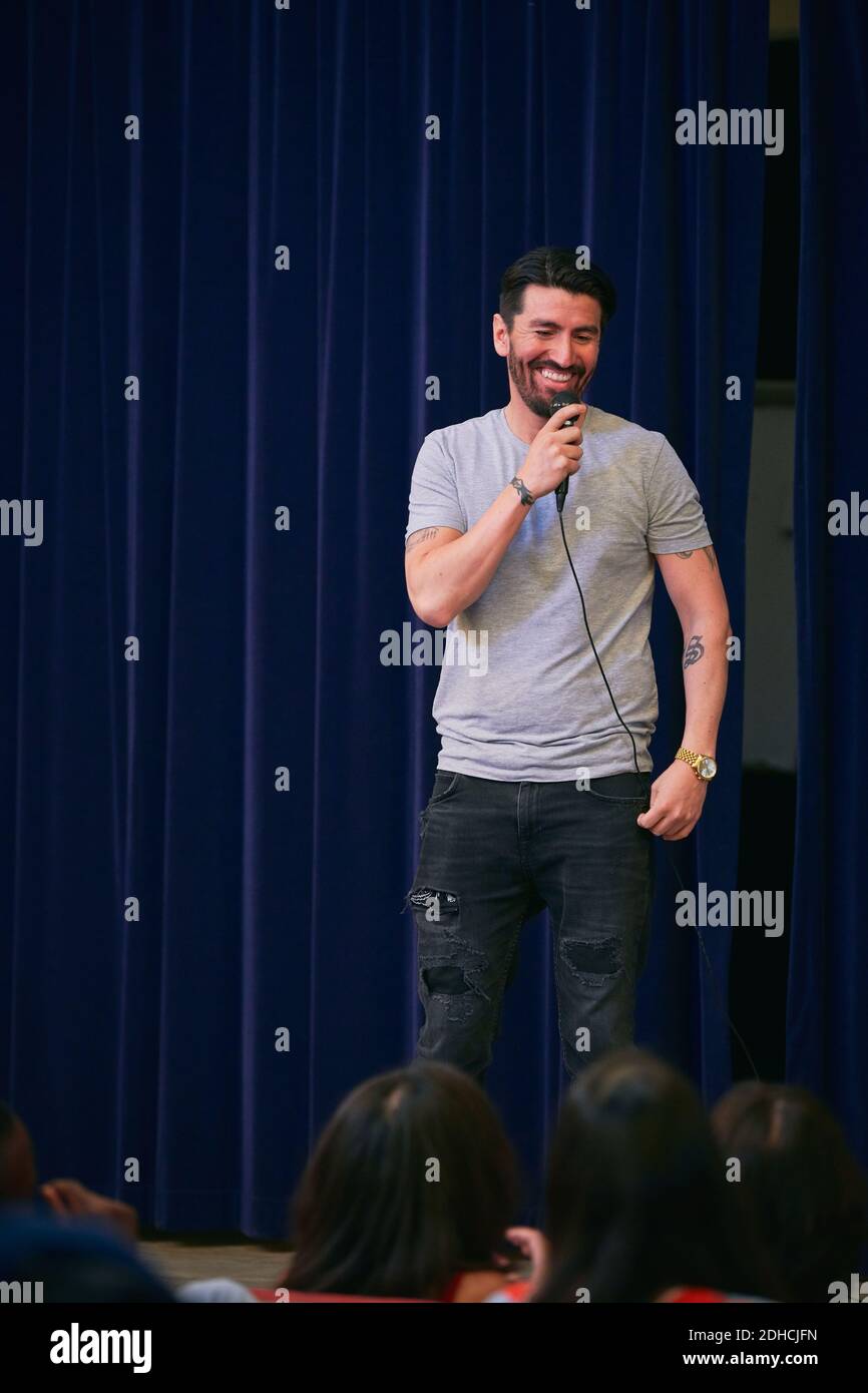 Chœur d'hommes souriants chantant dans le microphone de l'auditorium Banque D'Images Chœur d'hommes souriants chantant dans le microphone de l'auditorium Banque D'Images