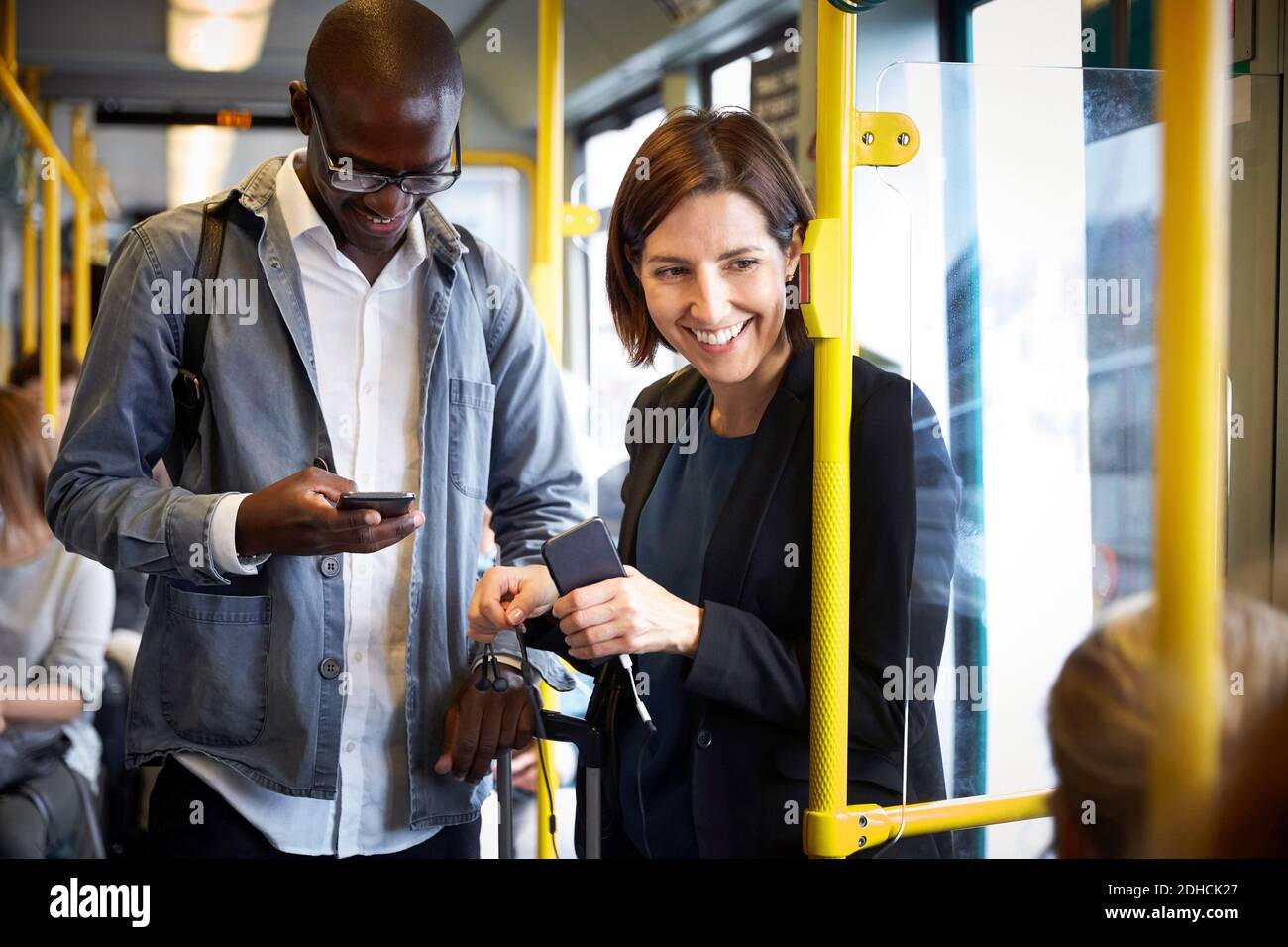 Des voyageurs multiethniques souriants en tram Banque D'Images