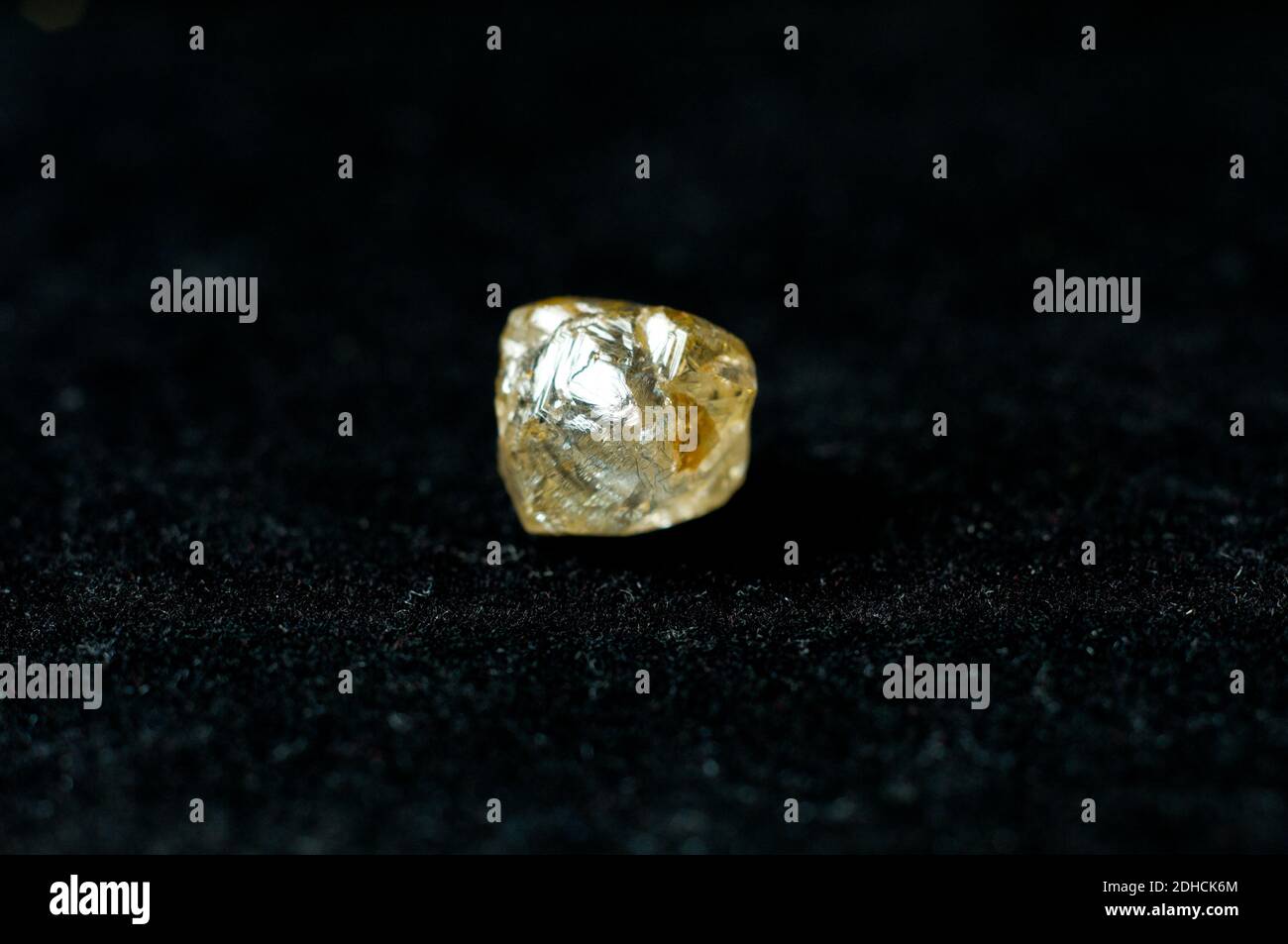 diamant jaune non coupé sur fond noir Banque D'Images