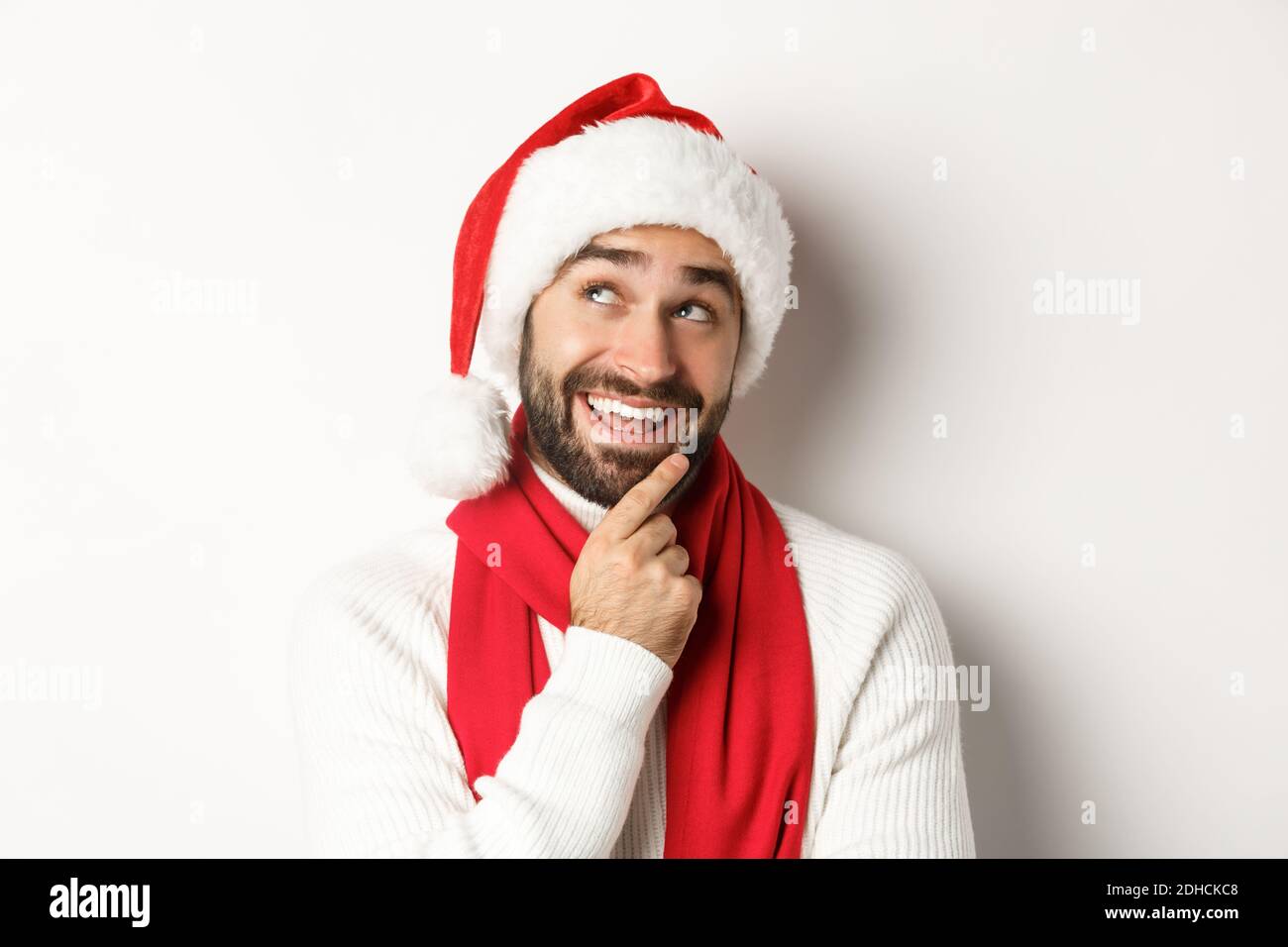 Concept fête nouvel an et vacances d'hiver. Gros plan sur un beau barbu qui a l'air attentif, en planifiant la liste de cadeaux de Noël dans Banque D'Images