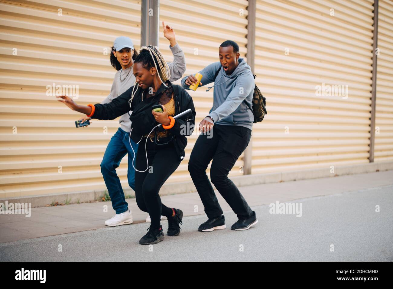 Nombre d'amis dansant sur le trottoir par l'obturateur ville Banque D'Images