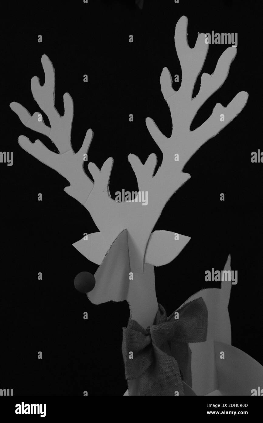 Une photo verticale d'une décoration faite à la main d'un cerf fabriqué à partir d'un papier avec un arrière-plan noir et noeud Banque D'Images