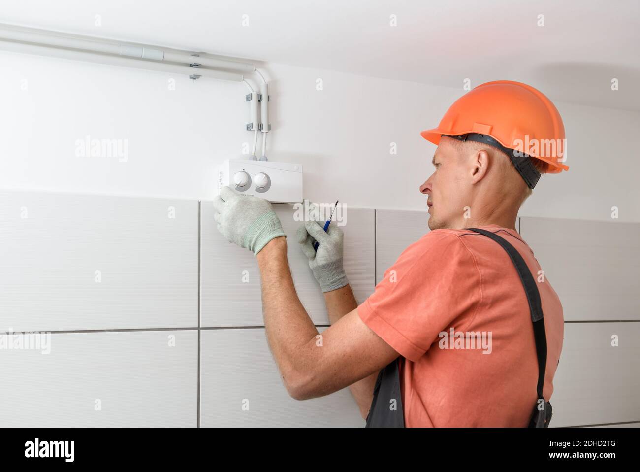 L'employé connecte le capteur d'humidité du système de ventilation. Banque D'Images