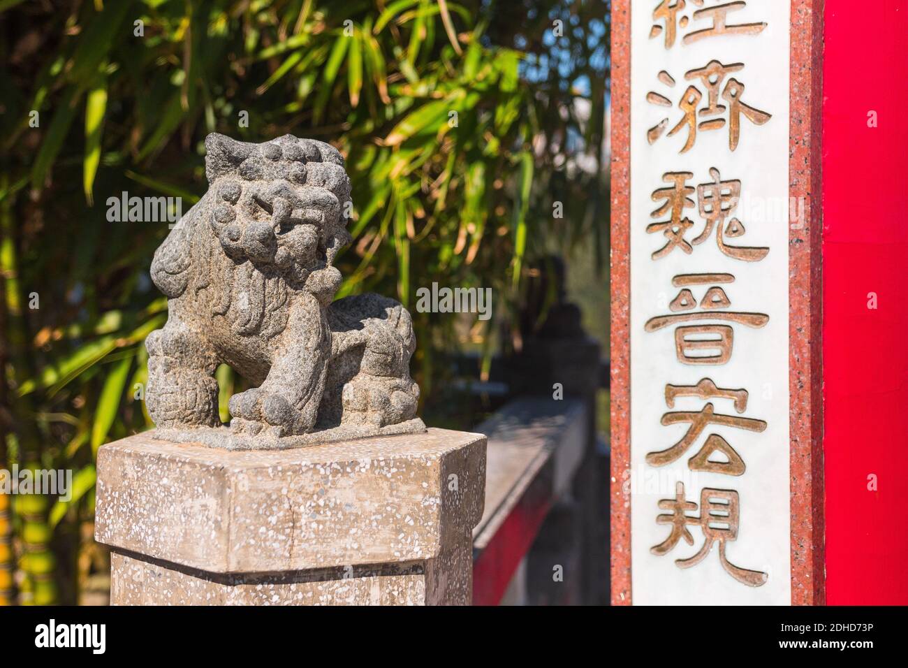 Belle statue de pierre de Lion en gros plan. Pavillon du lion (le pic), Hong Kong, Chine. Assis à côté de l'entrée du Pavillon écrit en chinois. Banque D'Images
