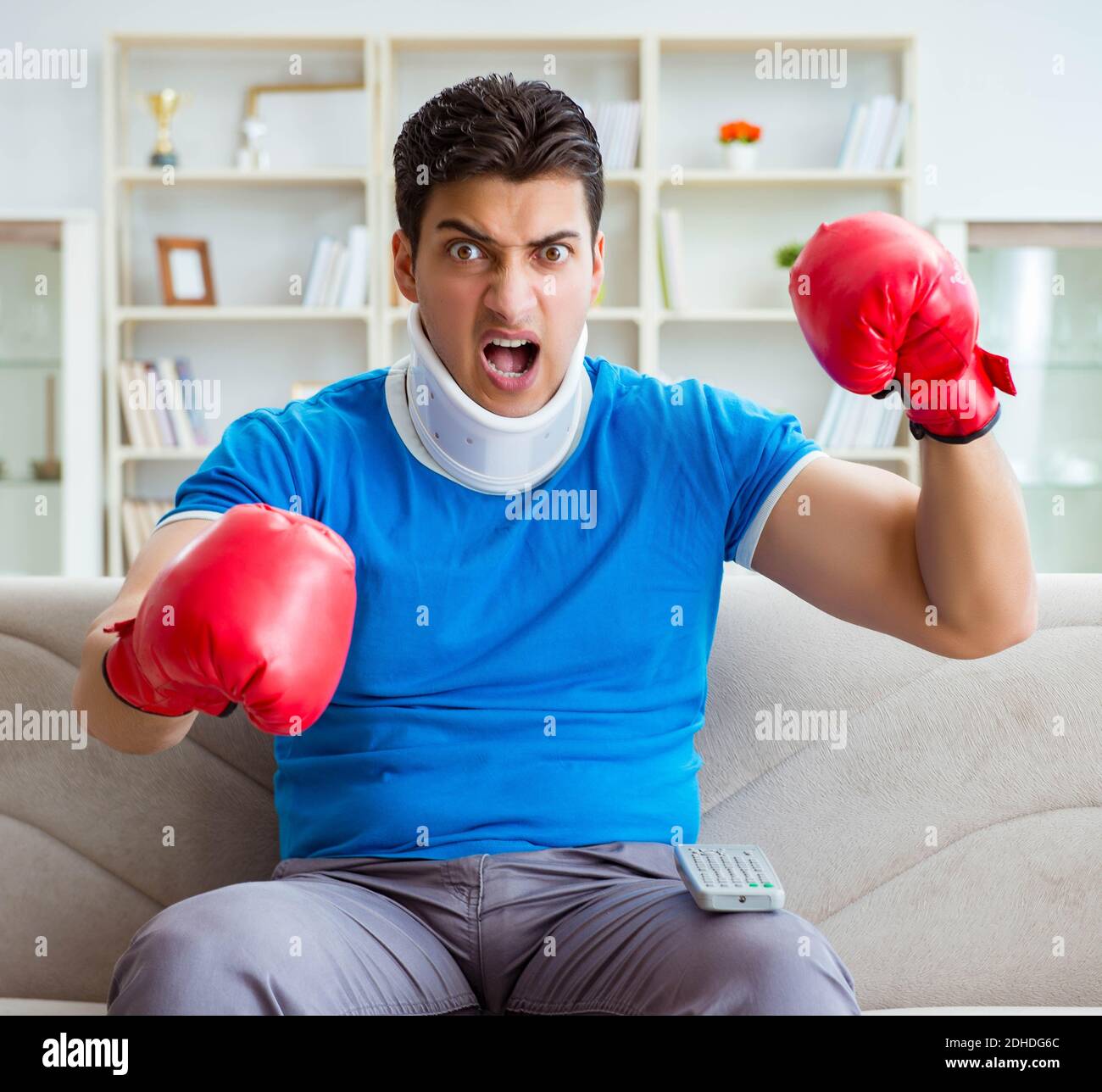 Homme avec blessure au cou à regarder la boxe à la maison Banque D'Images