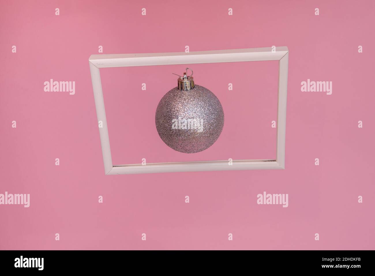 Boule de Noël argentée flottante dans un cadre photo. Arrière-plan abstrait de Noël Banque D'Images