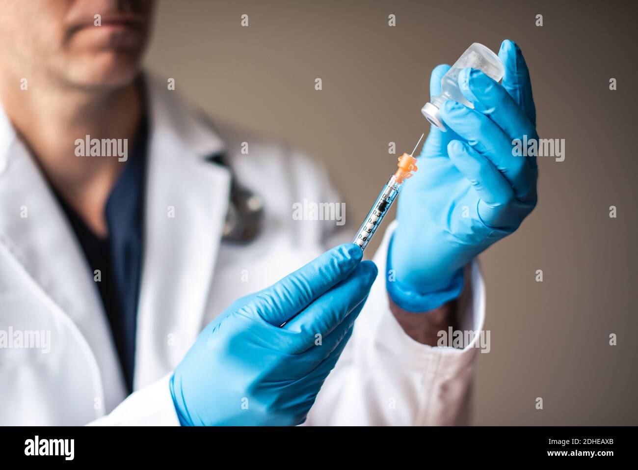Médecin en pelage blanc en tirant le vaccin dans une seringue pour injection. Banque D'Images
