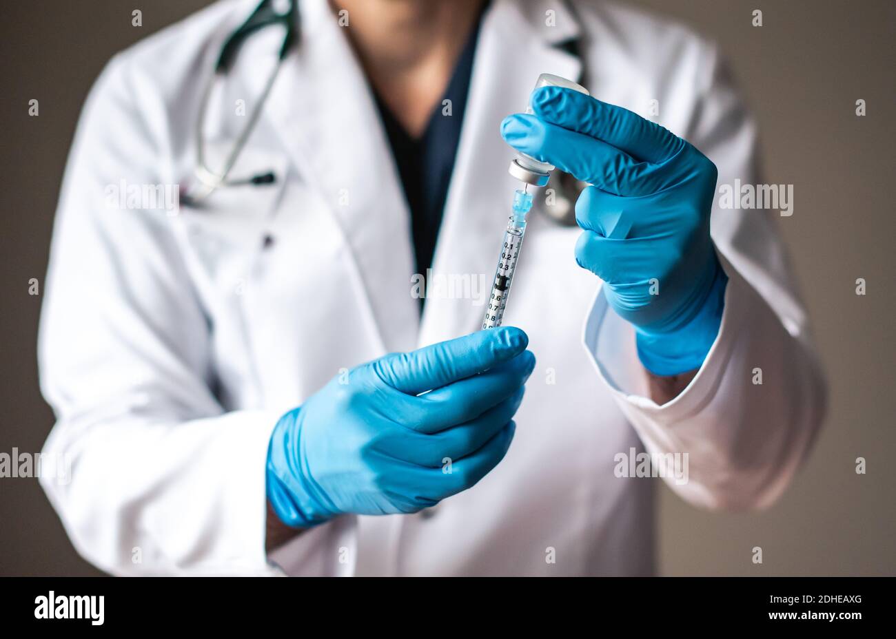 Médecin en pelage blanc en tirant le vaccin dans une seringue pour injection. Banque D'Images