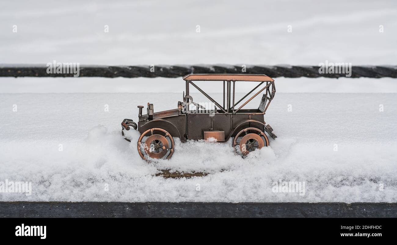 Jouet, modèle d'une voiture rétro se trouve dans la rue dans la neige profonde Banque D'Images