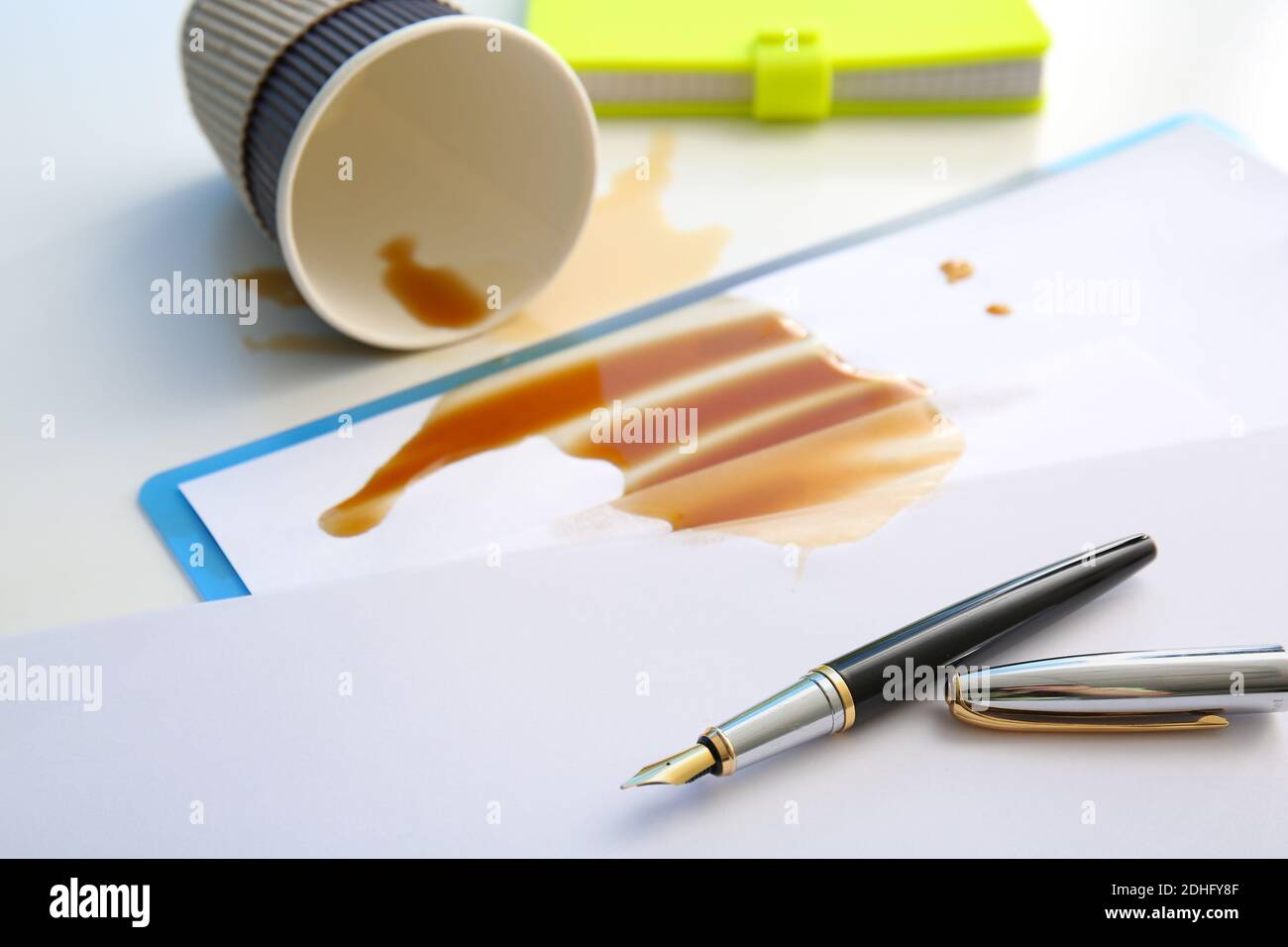 Papeterie, gobelet renversé et café renversé sur une table de bureau Banque D'Images Papeterie, gobelet renversé et café renversé sur une table de bureau Banque D'Images