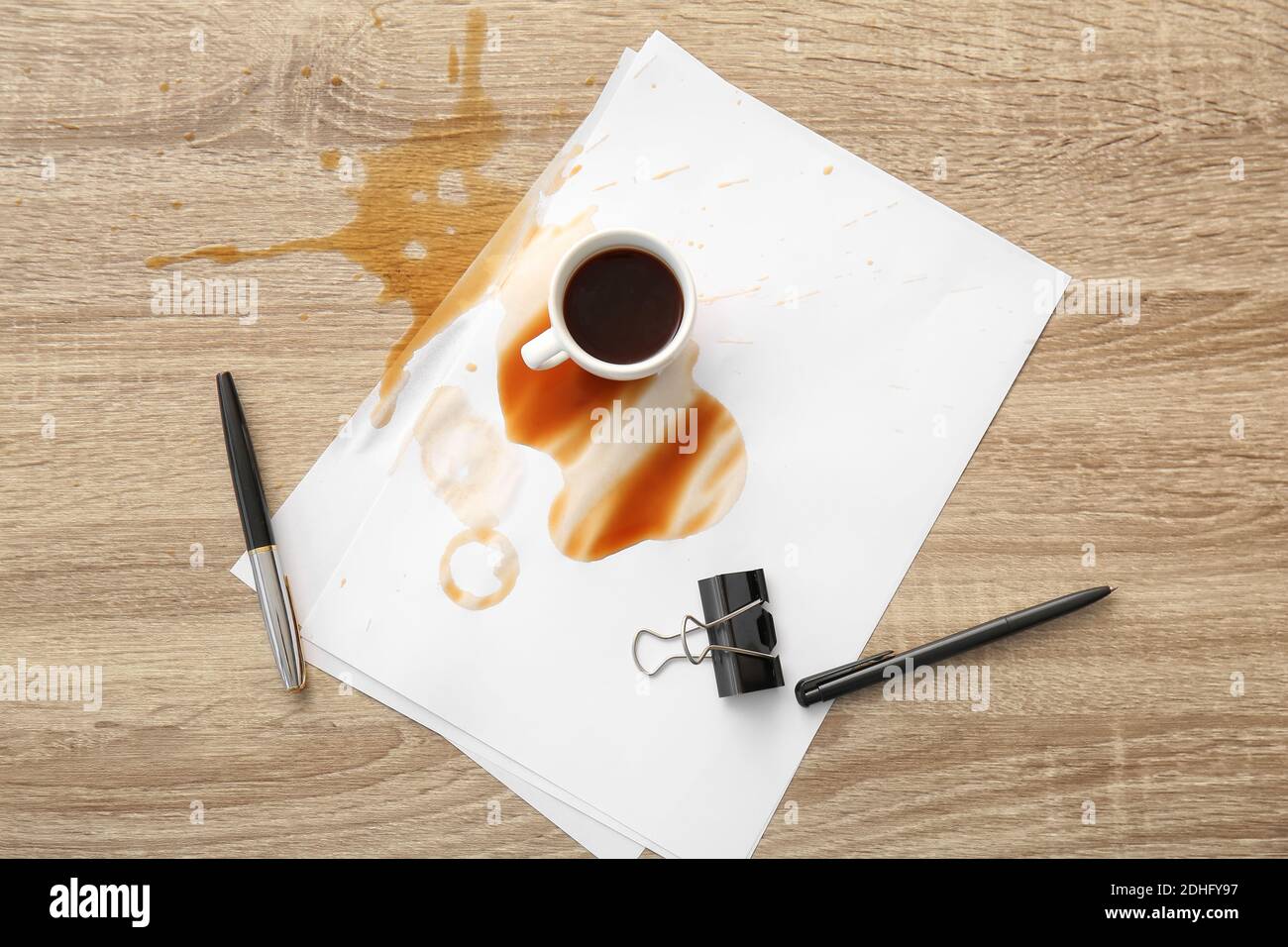 Papeterie, tasse et café renversé sur une table de bureau Banque D'Images Papeterie, tasse et café renversé sur une table de bureau Banque D'Images
