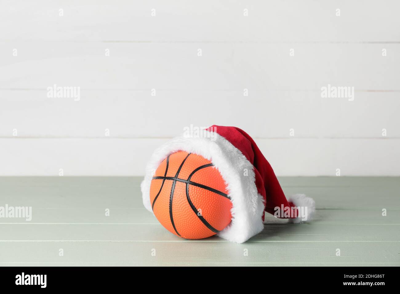 Chapeau de père Noël avec ballon pour jouer au basket-ball sur table Photo  Stock - Alamy