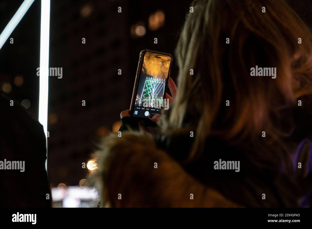New York, États-Unis. 10 décembre 2020. Une femme prend des photos avec un téléphone cellulaire pendant la cérémonie pour éclairer la menorah pour marquer la première nuit de Hanoukkah sur Pulitzer Fountain plaza. Événement annuel organisé par l'Organisation des jeunes de Lubavitch où le rabbin Shmuel Butman est le directeur. Menorah installé sur la plaza est reconnu comme la menorah la plus lagest au monde. Cette année, la menorah a été couverte de lumières à DEL pour rendre hommage à plus de 27,000 New-Yorkais qui ont perdu la vie pendant la pandémie du coronavirus. (Photo de Lev Radin/Pacific Press) crédit: Pacific Press Media production Corp./Alay Live News Banque D'Images