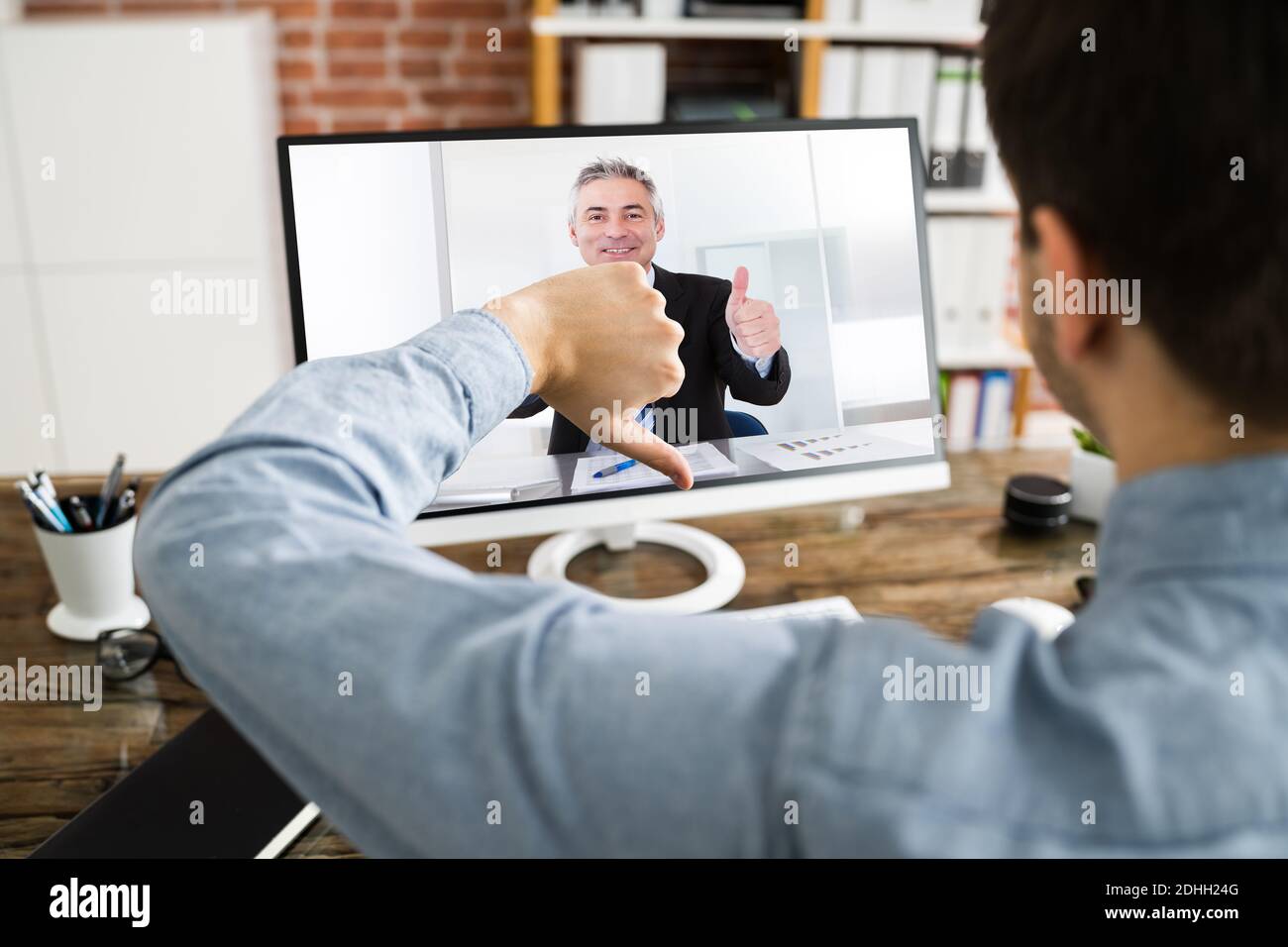Mains montrant le pouce vers le haut et vers le bas dans la visioconférence Banque D'Images