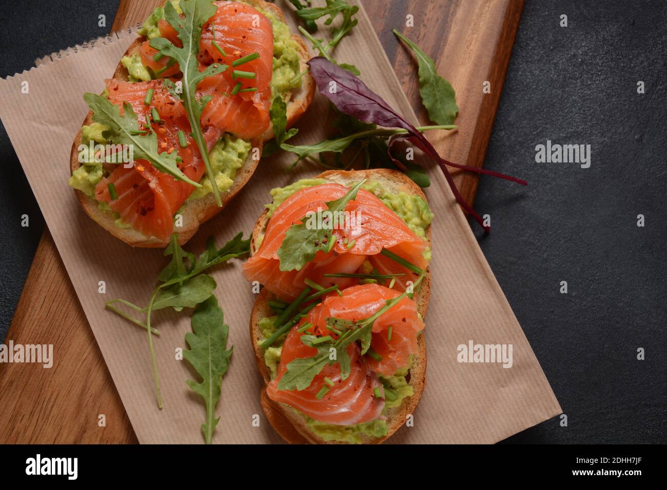 Pain à grains entiers avec pâte d'avocat et saumon, feuilles d'arugula. Banque D'Images
