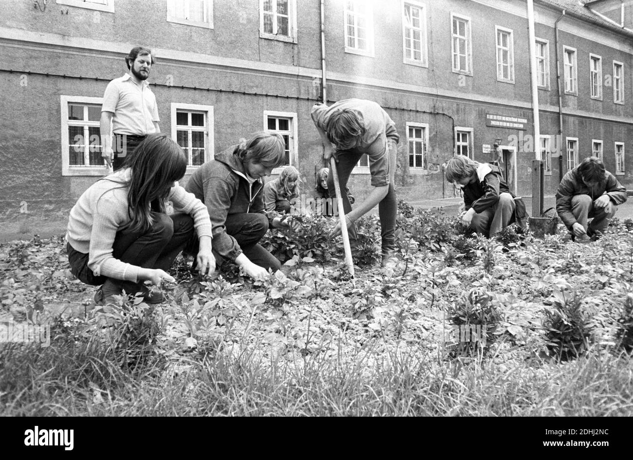 30 novembre 1983, Saxe, Zschepplin: Travaux de jardin avant, milieu des années 1980. Le château de Zschepplin est l'un des plus anciens complexes de châteaux de la région du Nord-Saxe et a été redessiné pour devenir une maison d'enfants dans les années 1950. Le bâtiment Renaissance de trois étages à quatre ailes a été érigé au-dessus d'un centre médiéval. En arrière-plan au-dessus de l'entrée, il dit: «vive la fraternité ferme et indestructible entre la RDA et l'Union soviétique». Date exacte de l'enregistrement inconnue. Photo: Volkmar Heinz/dpa-Zentralbild/ZB Banque D'Images
