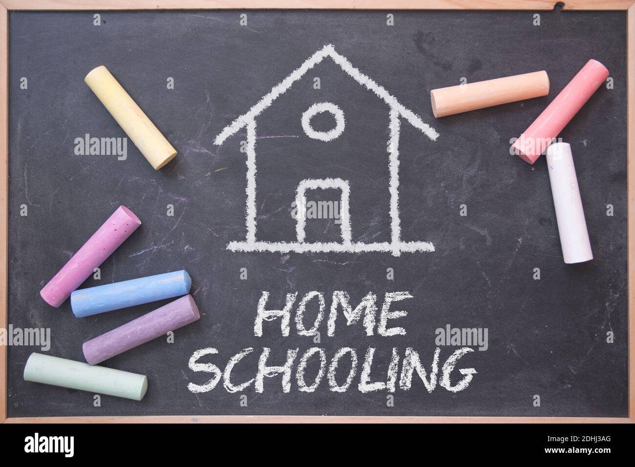 Concept de scolarisation à domicile sur un tableau noir avec quelques craies dessus. Modèle d'éducation alternative. Banque D'Images