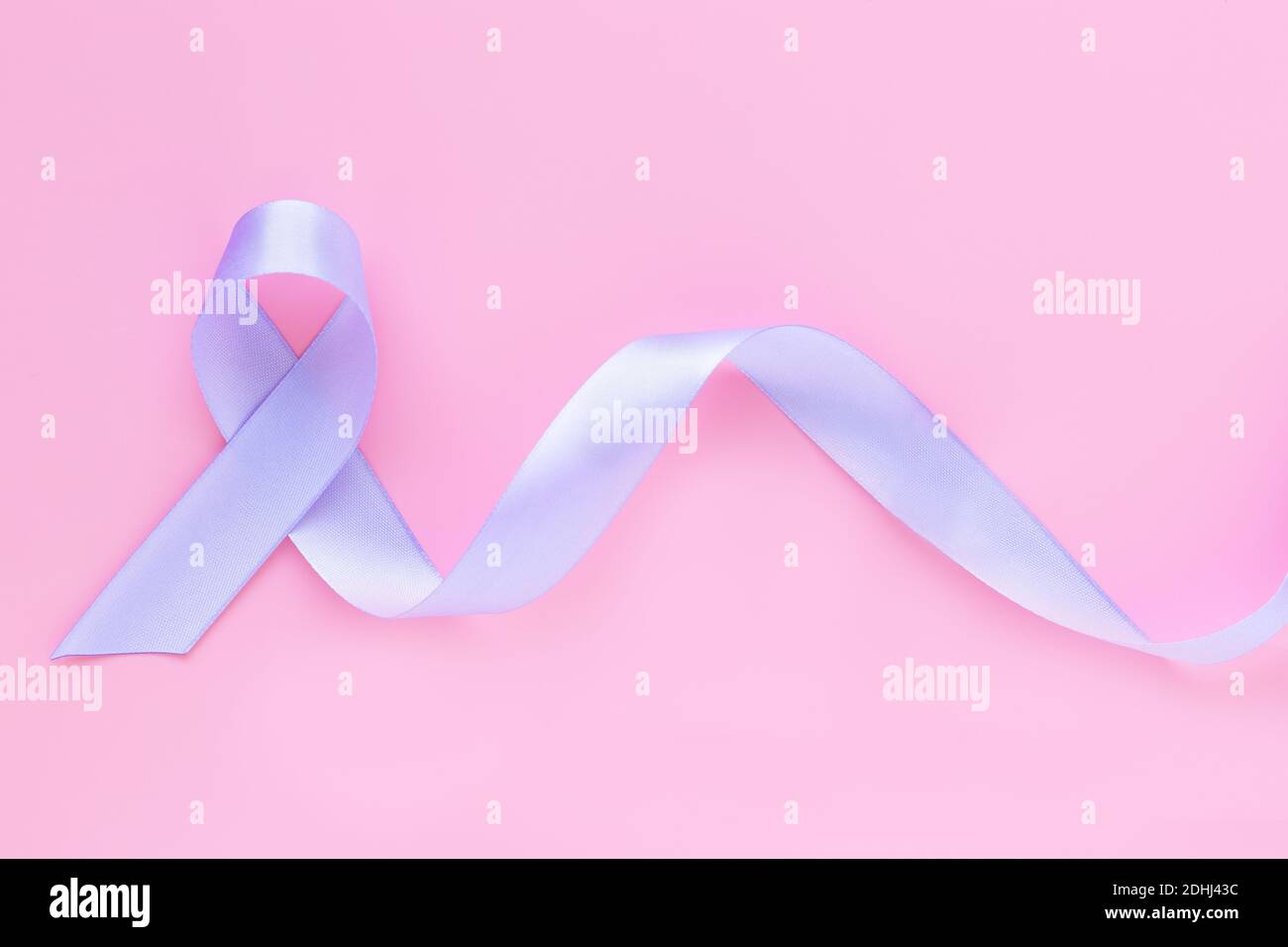 Ruban violet clair sur fond rose pastel avec espace de copie. Sensibilisation au cancer testiculaire, maladie d'Alzheimer, sensibilisation à l'épilepsie, World cancer Da Banque D'Images