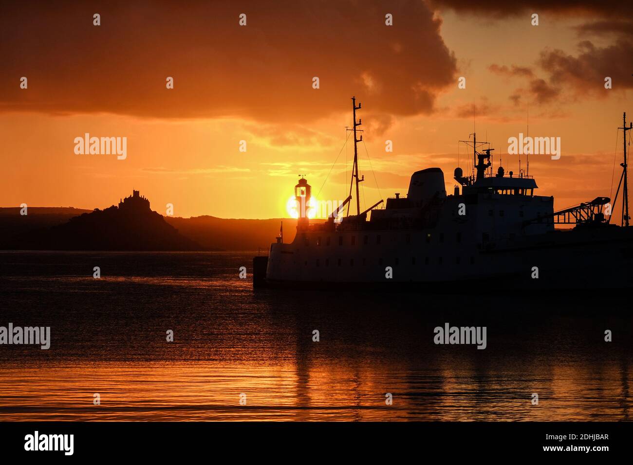 Le calme avant la tempête Alex, alors que le soleil se lève derrière le phare du port de Penzance le premier jour d'octobre. Banque D'Images