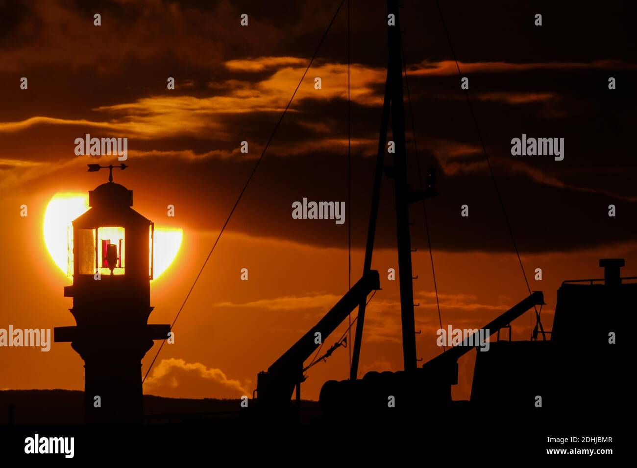 Le calme avant la tempête Alex, alors que le soleil se lève derrière le phare du port de Penzance le premier jour d'octobre. Banque D'Images