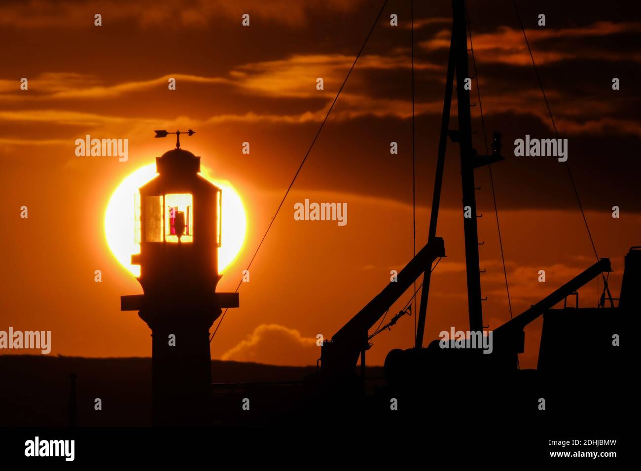 Le calme avant la tempête Alex, alors que le soleil se lève derrière le phare du port de Penzance le premier jour d'octobre. Banque D'Images