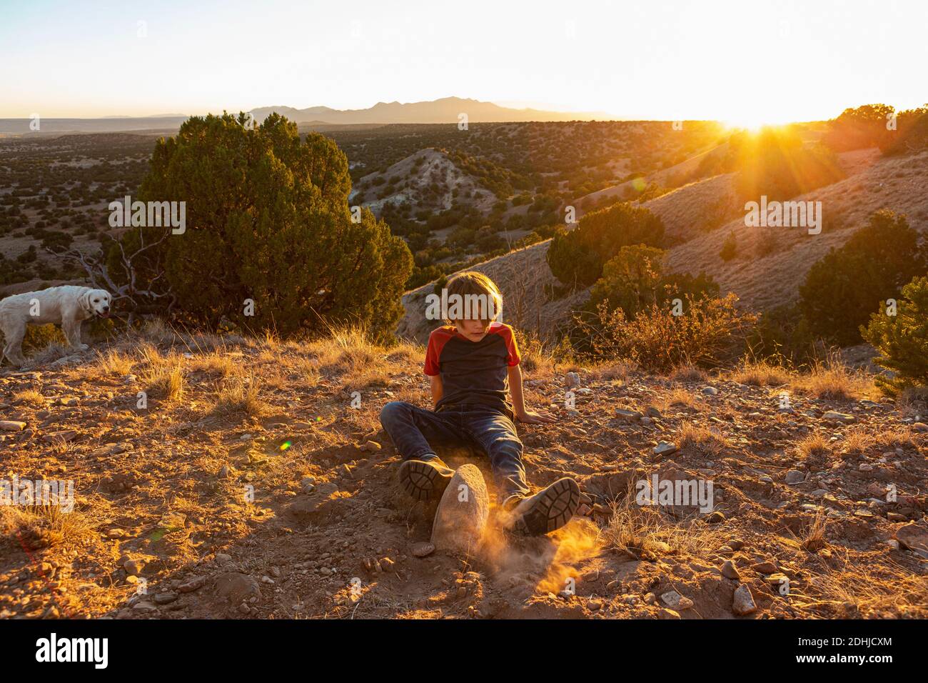 Jeune garçon à Galisteo Basin au coucher du soleil avec son anglais Crème Golden Retreiver Banque D'Images