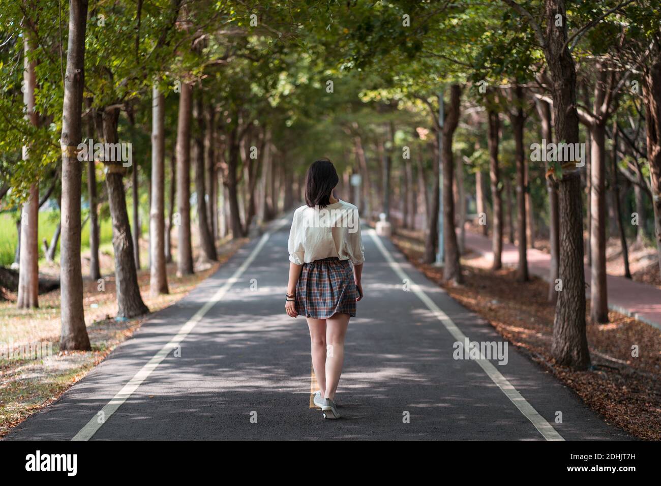 Vue arrière de la femme anonyme en tenue d'été marchant le long Chemin à Tanya Shen Green Bikeway Banque D'Images