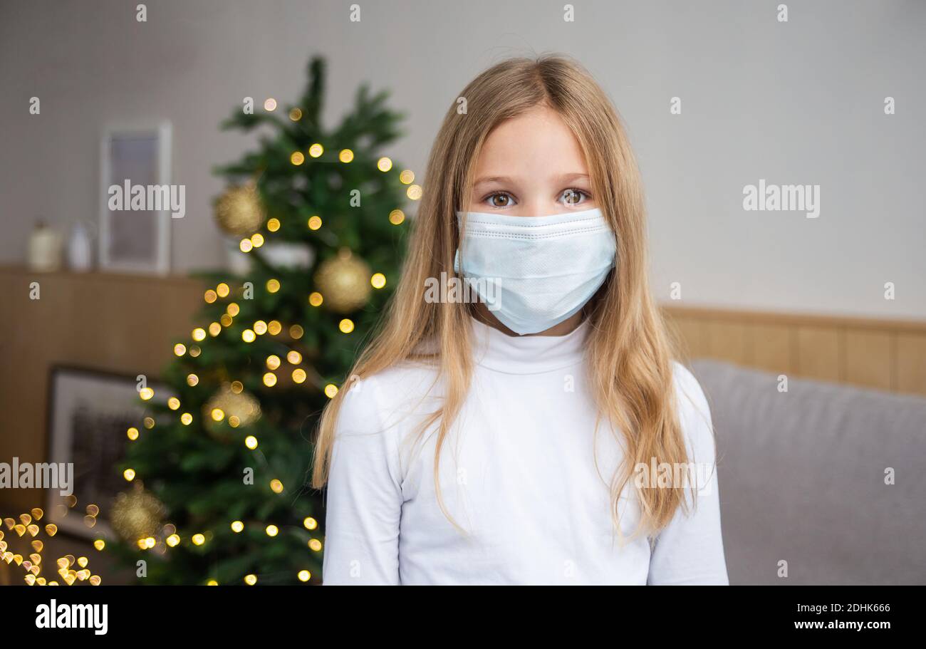 Petite fille portant un masque de protection sur le fond de l'arbre de  Noël. Triste visage d'enfant avec masque chirurgical. Fête de Noël et  social distancer pendant Photo Stock - Alamy