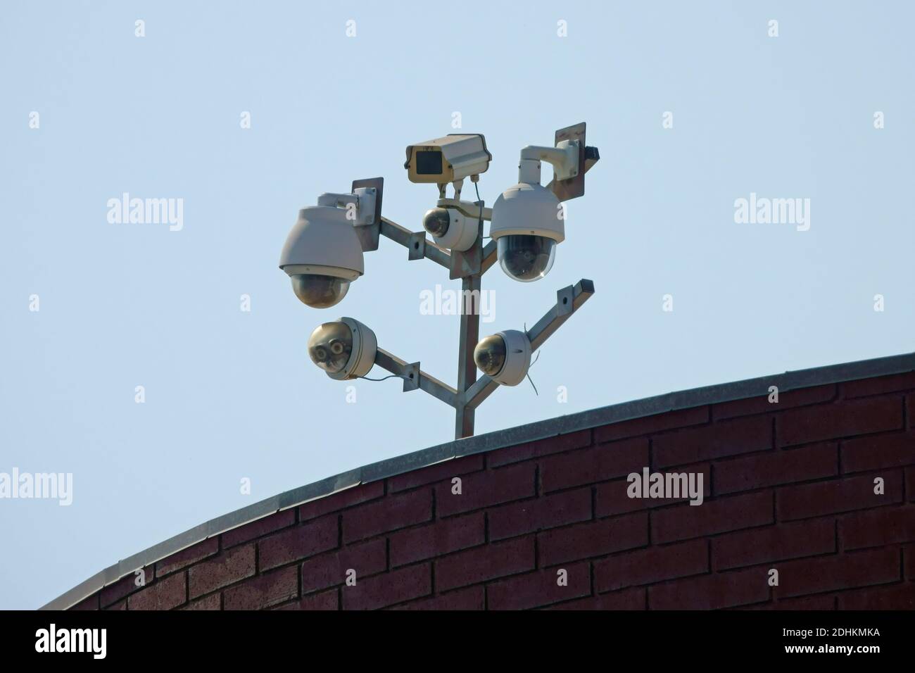 Un ensemble de caméras de sécurité modernes assure la surveillance depuis le sommet d'un bâtiment d'affaires dans une ville pendant la journée. Banque D'Images