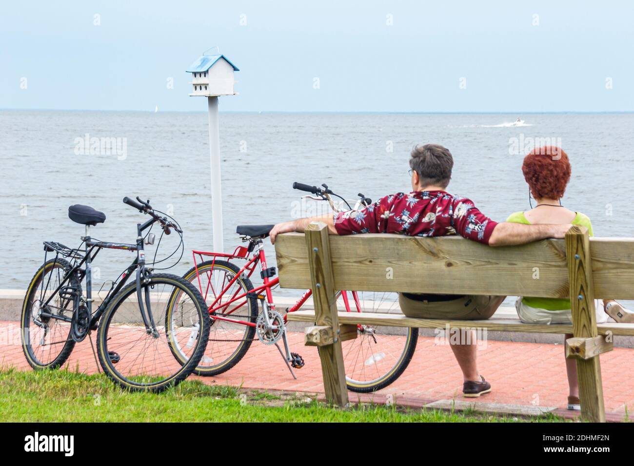 Alabama Fairhope Municipal Park Pier Mobile Bay, homme femme couple vélos motards se reposant banc, Banque D'Images