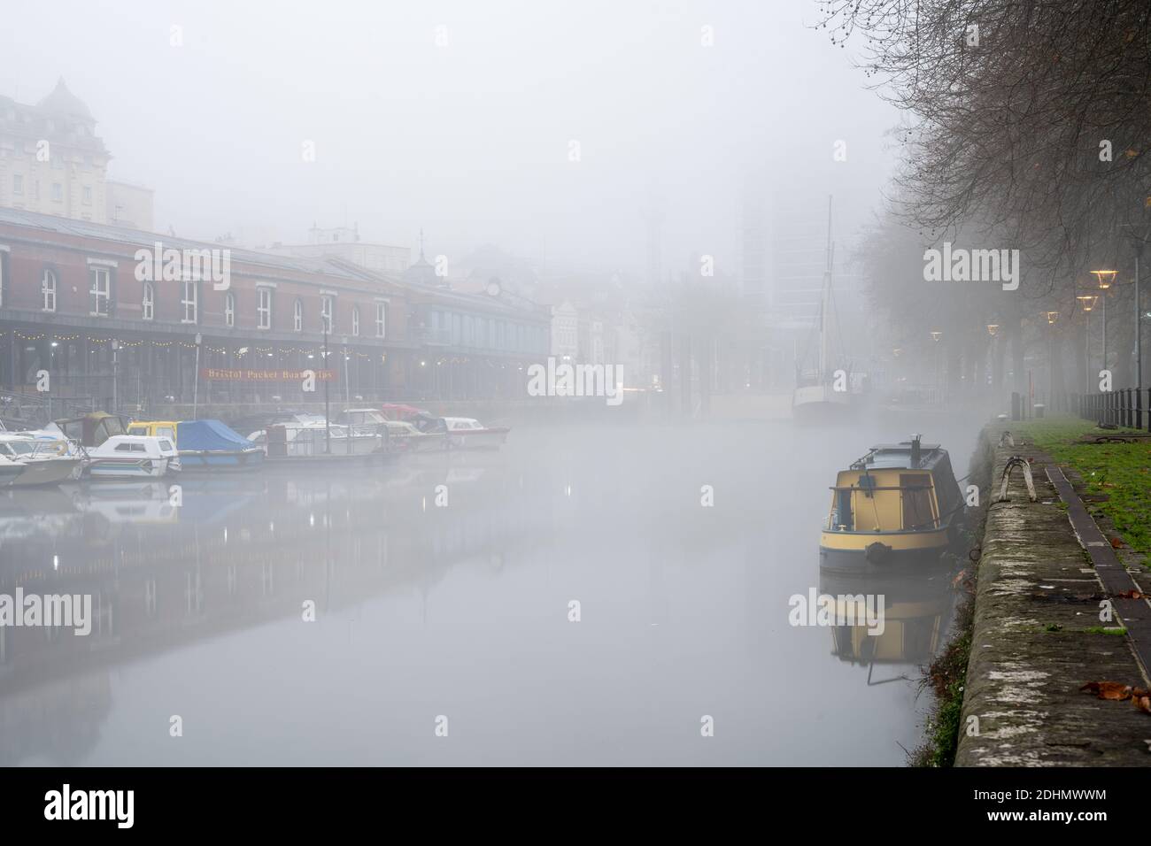 Les bateaux et les bâtiments du Harbourside de Bristol sont enveloppés de brouillard le matin de l'automne. Banque D'Images