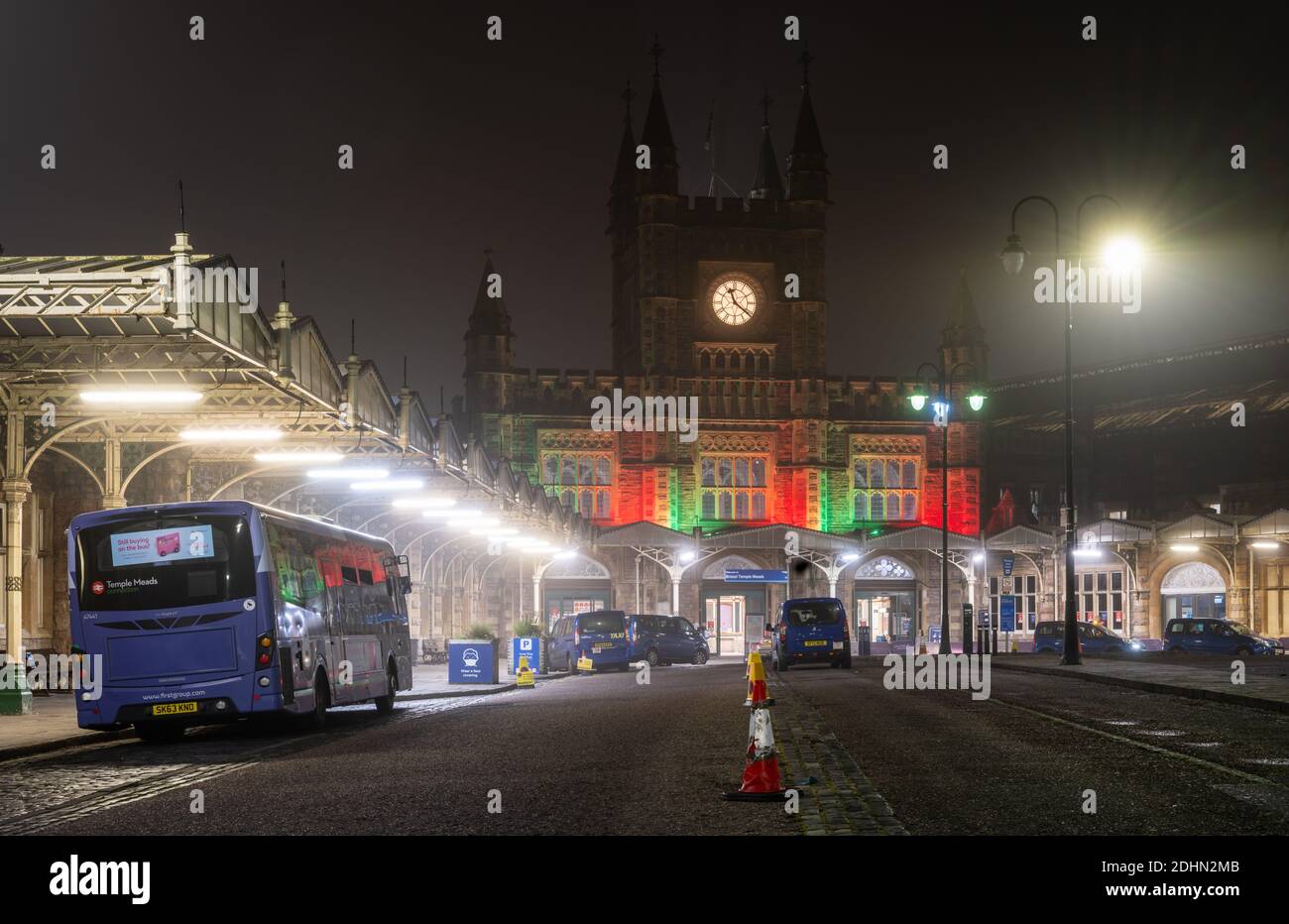 Des taxis et un bus vous attendent devant l'entrée principale de la gare Temple Meads de Bristol, éclairée en rouge la nuit. Banque D'Images
