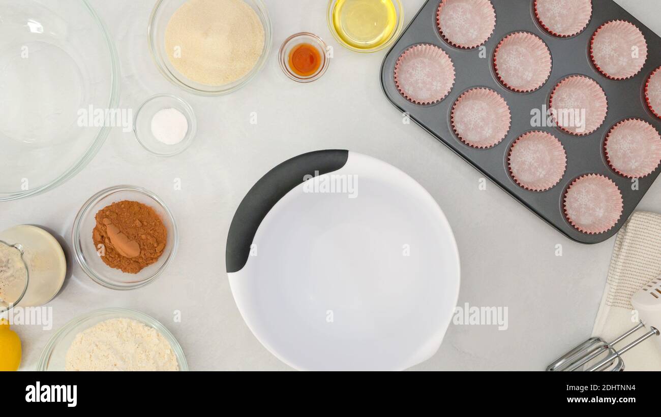 Moule à muffins avec des sacs de cupcakes en papier et des ingrédients pour les muffins au chocolat ou les cupcakes au chocolat pour les recettes de gros plan sur la table de cuisine. Banque D'Images