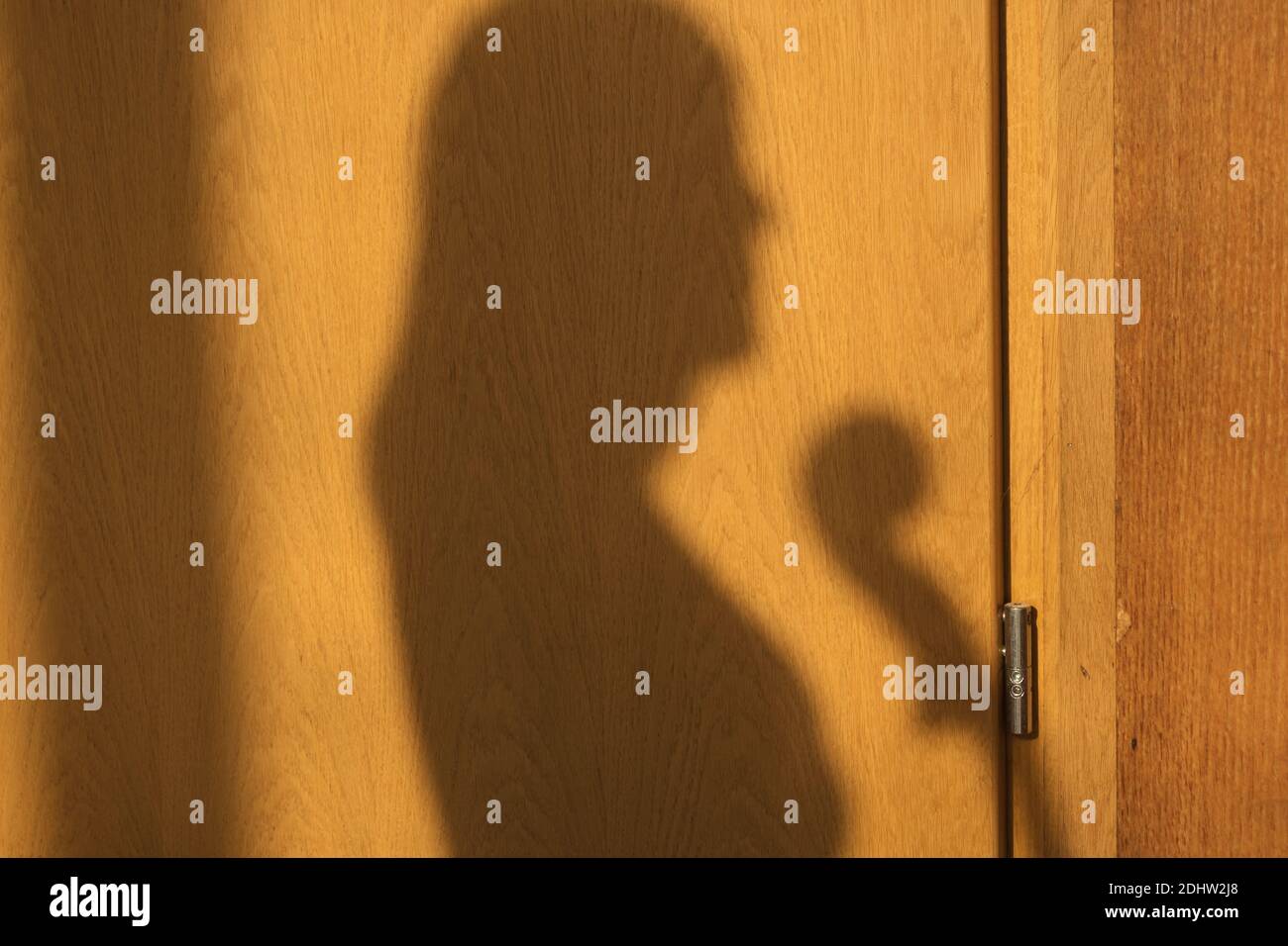 Silhouette d'une fille avec violoncelle sur une surface en bois. Banque D'Images