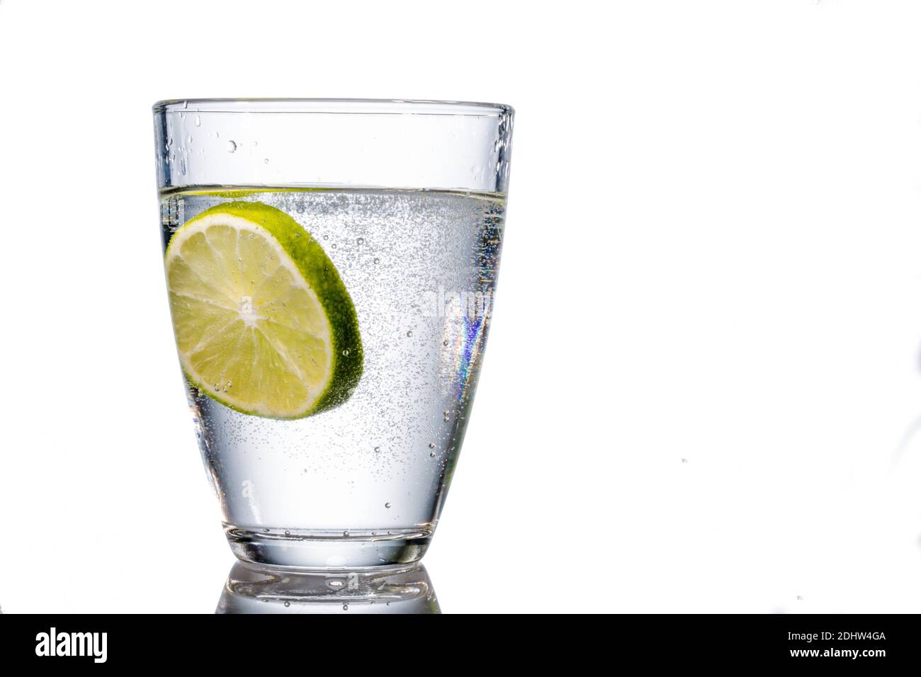 Ein Glas mit Wasser und vor Limette weissem Hintergrund, Symbolfoto Wasserbedarf und für Trinkwasser, Verbrauch, Glas, limette, Banque D'Images