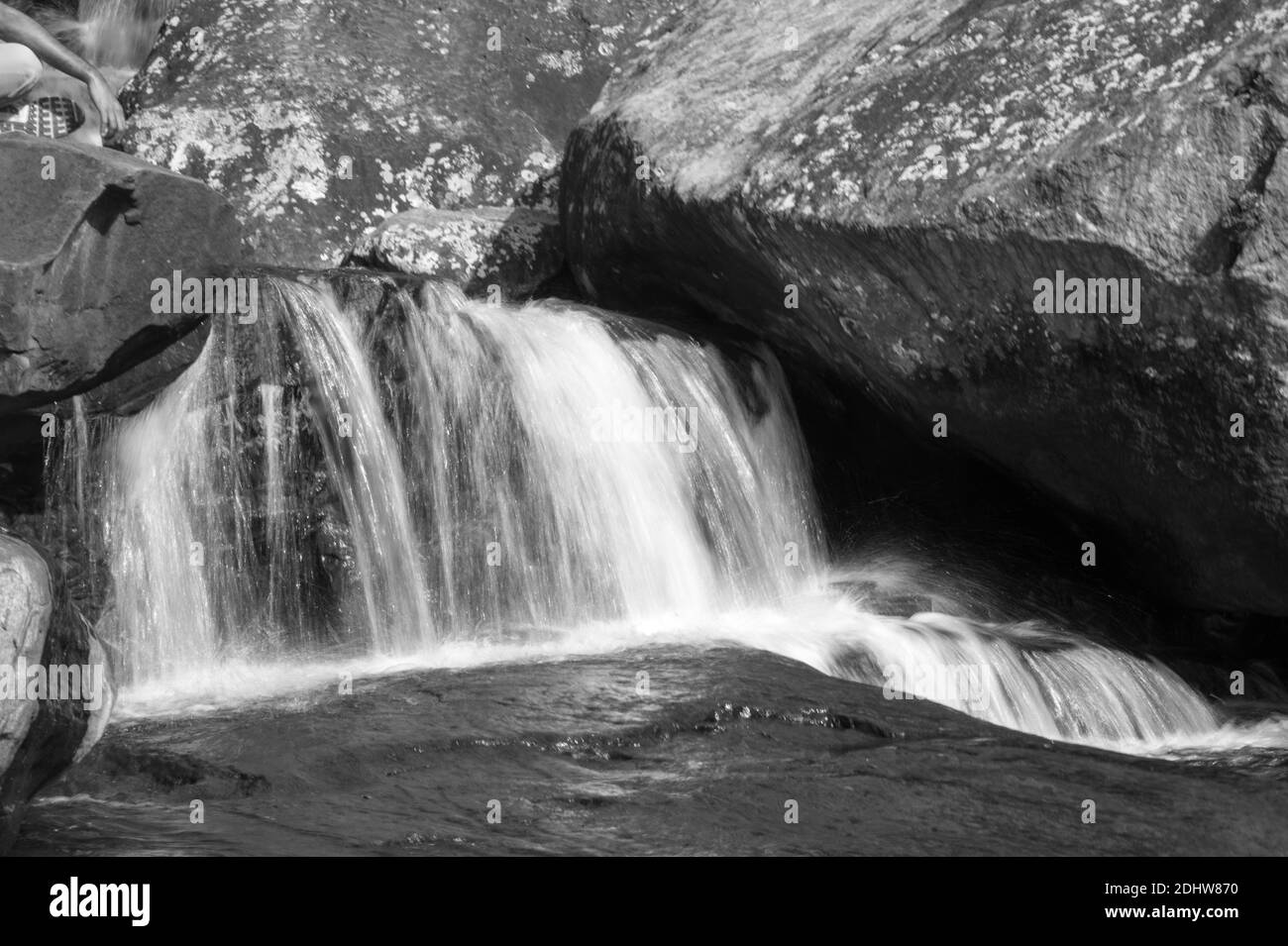 Paysages charmants d'une formation de roche et d'une chute d'eau dans un ruisseau de montagne d'eau douce. Le regard vitreux sur l'eau rend la scène paisible et sereine Banque D'Images