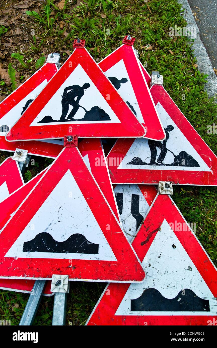 Viele Verkehrszeichen einer Strassenbaustelle liegen übereinander am Boden. Banque D'Images