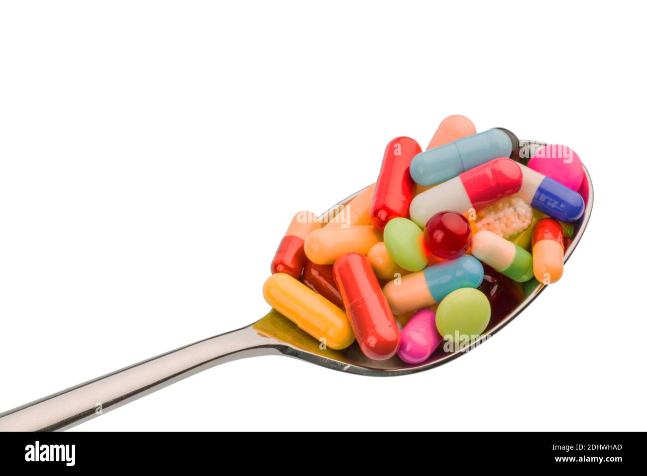 Viele bunte Tabletten auf einem Löffel. Dienstleistungen für Tablettensucht und Missbrauch von Medikamenten. Banque D'Images