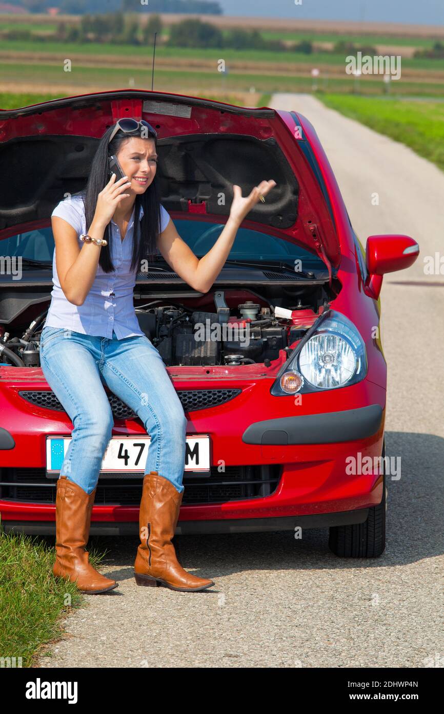 Junge Frau mit einer Motorpanne am Auto Banque D'Images