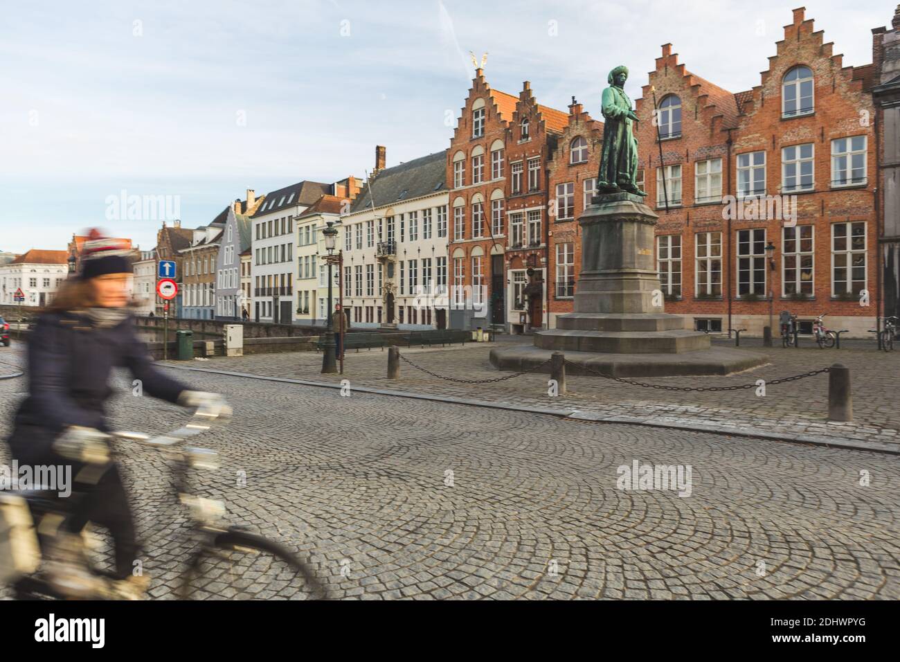 Une femme à vélo se balade au-dessus du vieux centre médiéval de Bruges, en Belgique. Banque D'Images