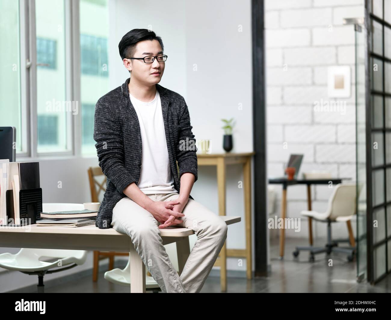 portrait d'un jeune homme d'affaires asiatique assis au bureau vue sur l'extérieur Banque D'Images