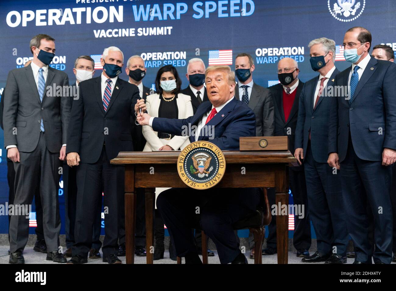 Le président américain Donald Trump, remet un stylo au vice-président Mike  Pence après avoir signé un décret exécutif sur l'accès aux vaccins lors du  sommet Operation Warp Speed Vaccine dans l'Auditorium de
