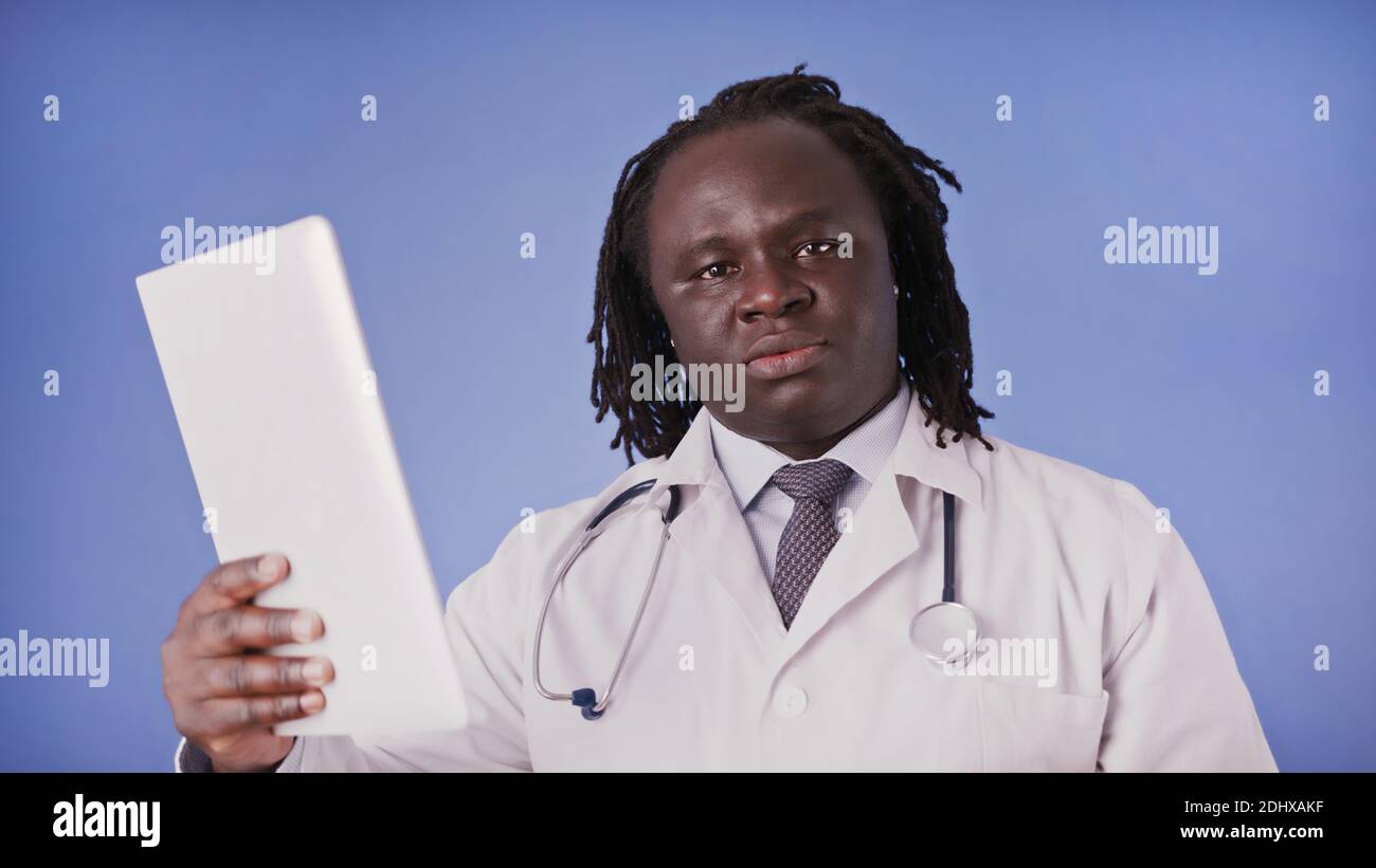Médecin homme noir utilisant une tablette pour la recherche médicale ou la présentation. Photo de haute qualité Banque D'Images