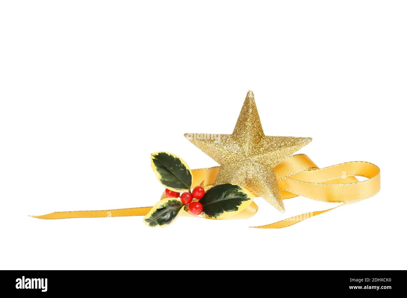 Motif de Noël, étoile dorée scintillante avec houx et ruban doré en spirale isolé du blanc Banque D'Images