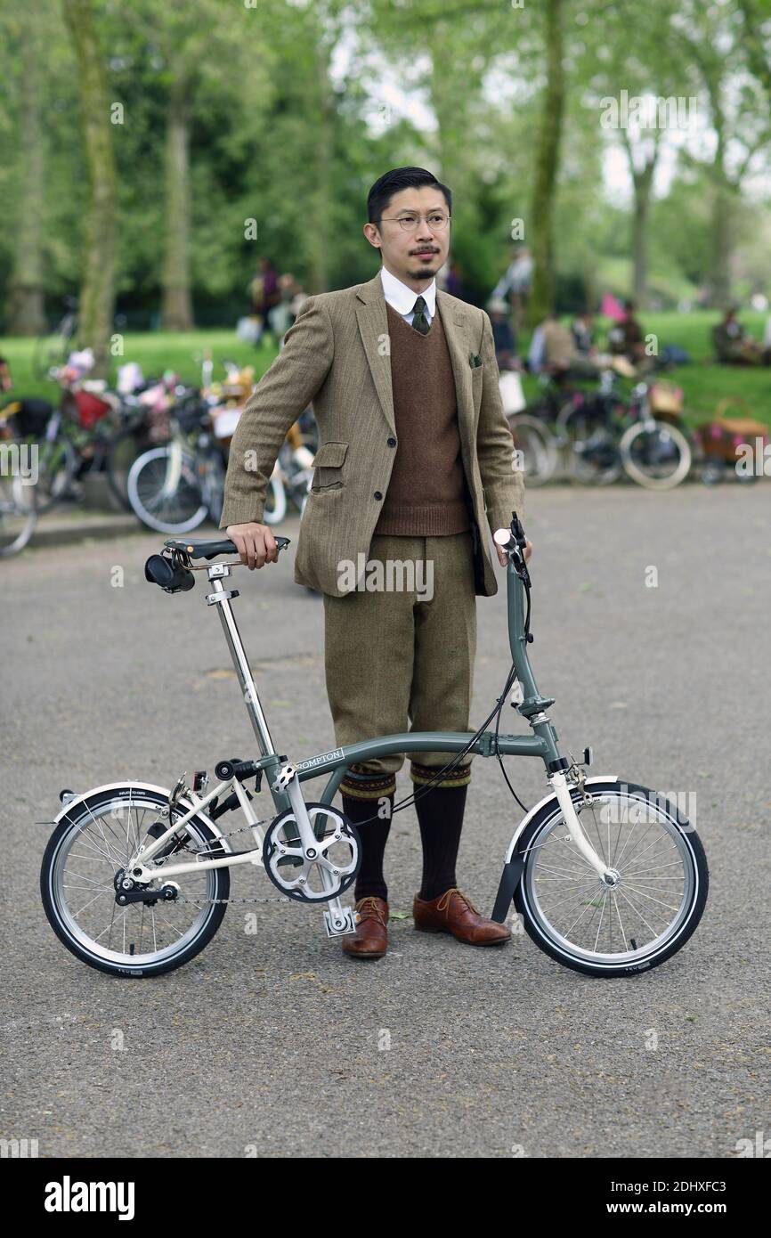 Jeune homme vêtu d'un costume debout à côté d'un vélo à la Tweed Run à Londres, Royaume-Uni Banque D'Images